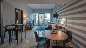 Un salon moderne avec un coin repas, de grandes fenêtres et une vue sur la ville.
