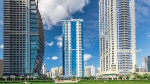 A modern high-rise building with a sleek, vertical design and a prominent blue facade. - Blueground | JLT, pool, nr Dubai Marina (Dubai)