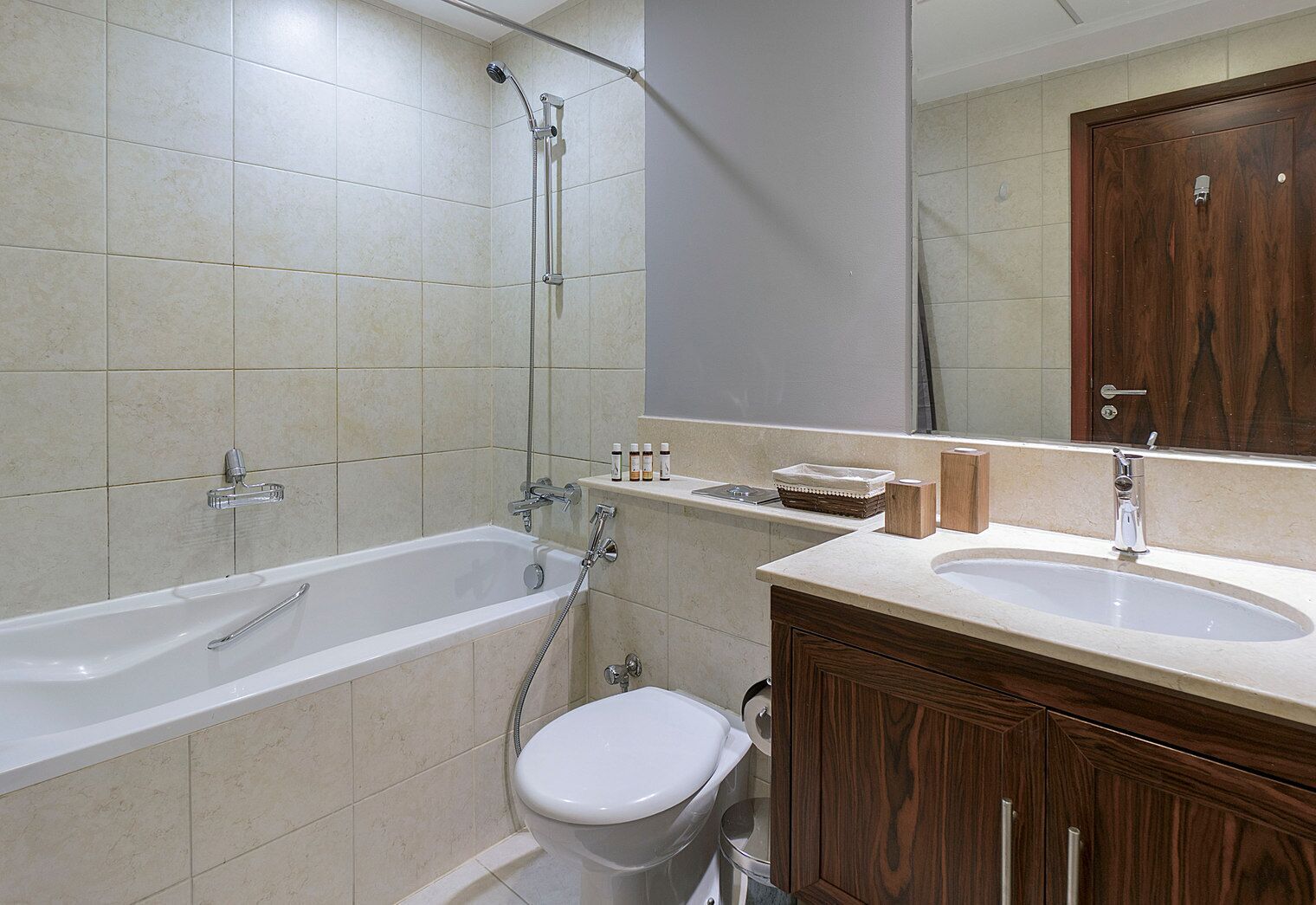 A bathroom with a bathtub, toilet, sink, and wooden cabinets.