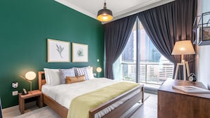 Une chambre à coucher avec un lit, des tables de chevet, une lampe, une horloge et des œuvres d’art encadrées accrochées au mur.