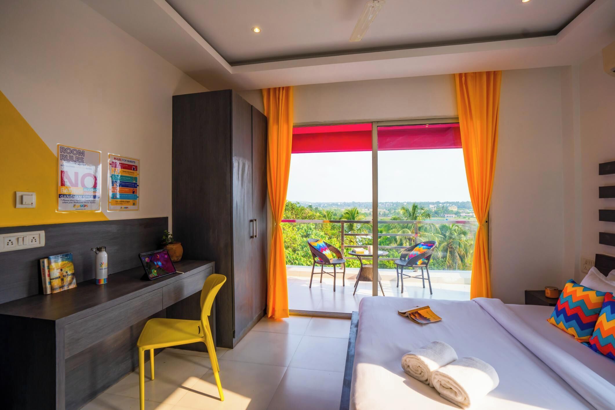 Une chambre d’hôtel moderne équipée d’un lit, d’un bureau, d’une chaise et d’un balcon avec vue.
