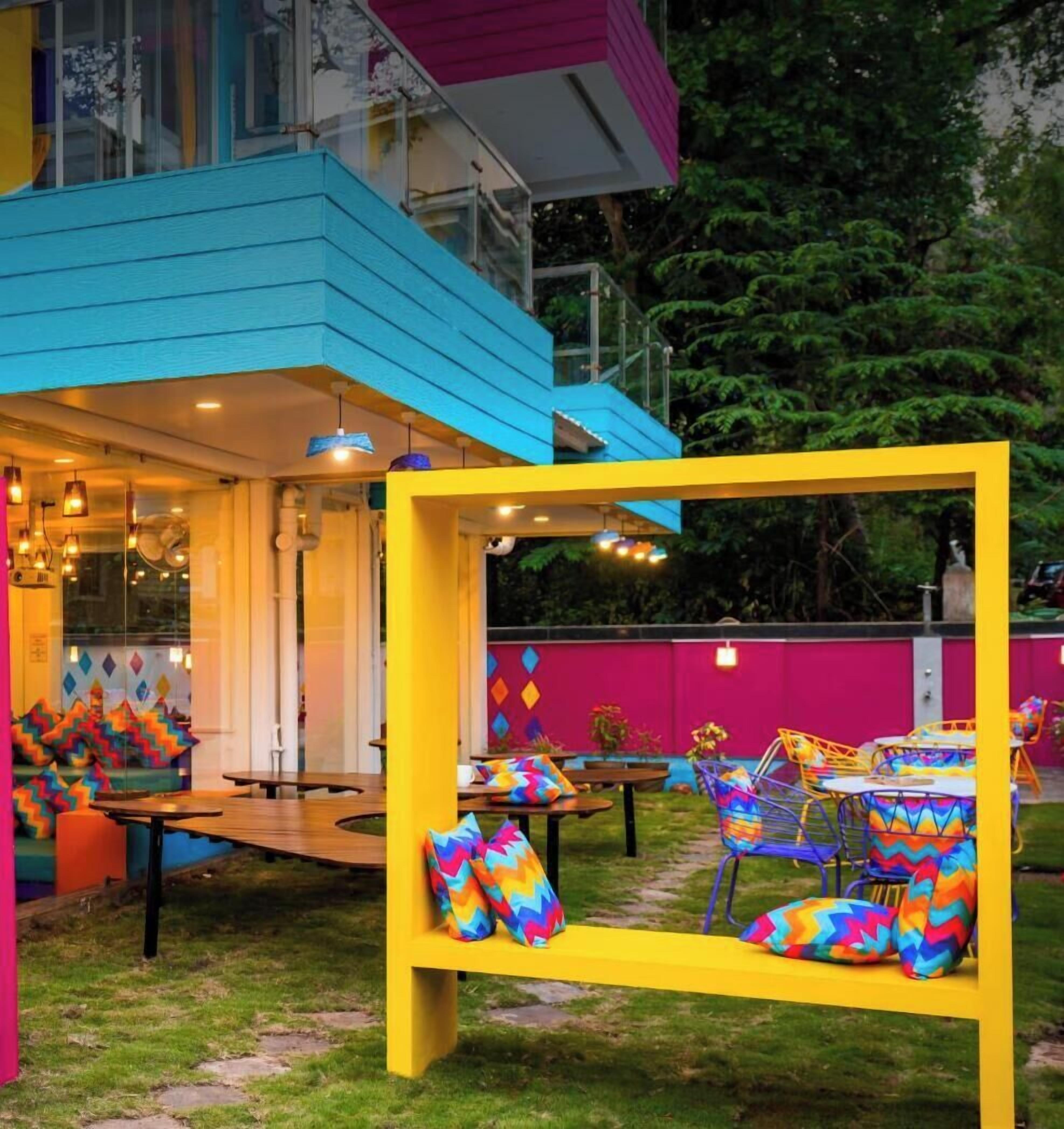Un espace extérieur accueillant, agrémenté de coussins aux couleurs vives et doté d’une architecture moderne.