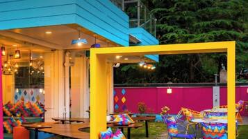 Un espace extérieur accueillant, agrémenté de coussins aux couleurs vives et doté d’une architecture moderne.