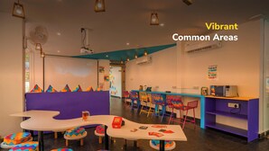 Un espace commun accueillant, agrémenté de sièges colorés, de tables et d’une variété de chaises.