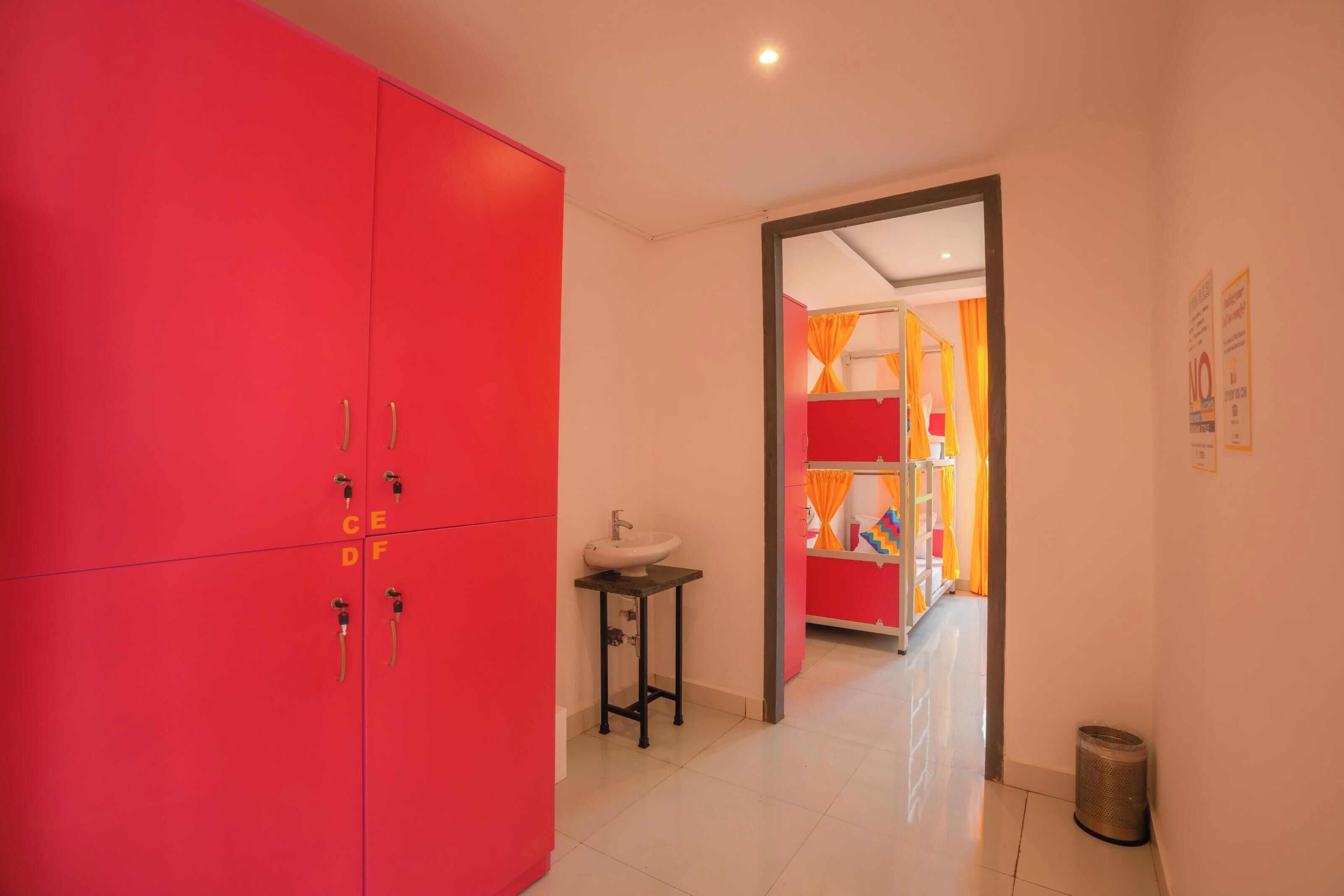 Un baño moderno con un armario rojo, un lavabo y un espejo.