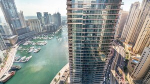 A high-rise building with a marina in the foreground. - Blueground | Dubai Marina, shared pool, nr Beach (Dubai)