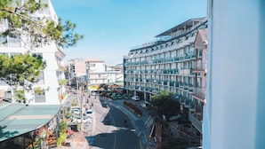 A multi-story hotel with balconies, a street view, and parked cars. - Phat Loi Hotel Dalat  (Xuan Huong - Da Lat)