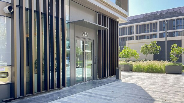 A modern building entrance with a glass door labeled "23A".