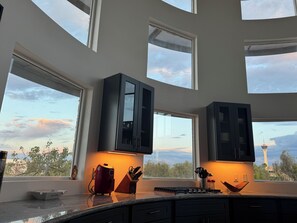 Enjoy expansive views of the surrounding landscape from the high ceiling kitchen with large windows.
