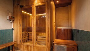 A sauna room with wooden benches, a bench outside, and a heater. - Famara Villa Bali by Blacksand (Cepaka)
