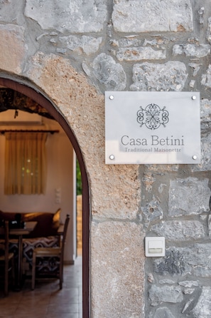 Eine Steinmauer mit einem Schild, auf dem 'Casa Betini Traditional Maisonette' steht.