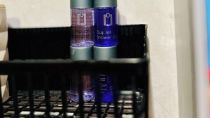A bathroom shelf with two bottles of shampoo and a bottle of shower gel. - HANCI PANSİYON (Edremit)