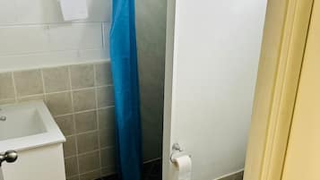 Een douche, handdoeken, zeep, toiletpapier