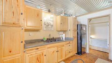 1 habitación, escritorio y tabla de planchar con plancha