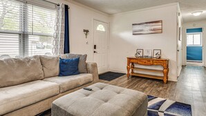 A living room with a beige sofa, a matching ottoman, a wooden coffee table, and a door with a decorative glass window. - 8 Mi to Dtwn Indianapolis: Family Home w/ Yard! (Indianapolis)