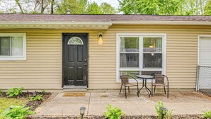A single-story house with a front door, two windows, and a small patio with two chairs and a table. - 8 Mi to Dtwn Indianapolis: Family Home w/ Yard! (Indianapolis)