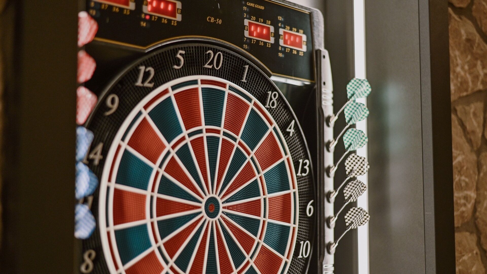 A dartboard with a dartboard and darts mounted on a wall.
