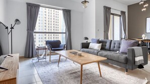 A modern living room with a sofa, armchair, and a coffee table. - Blueground | Jumeirah Beach Residence, pool, nr Marina (Dubai)