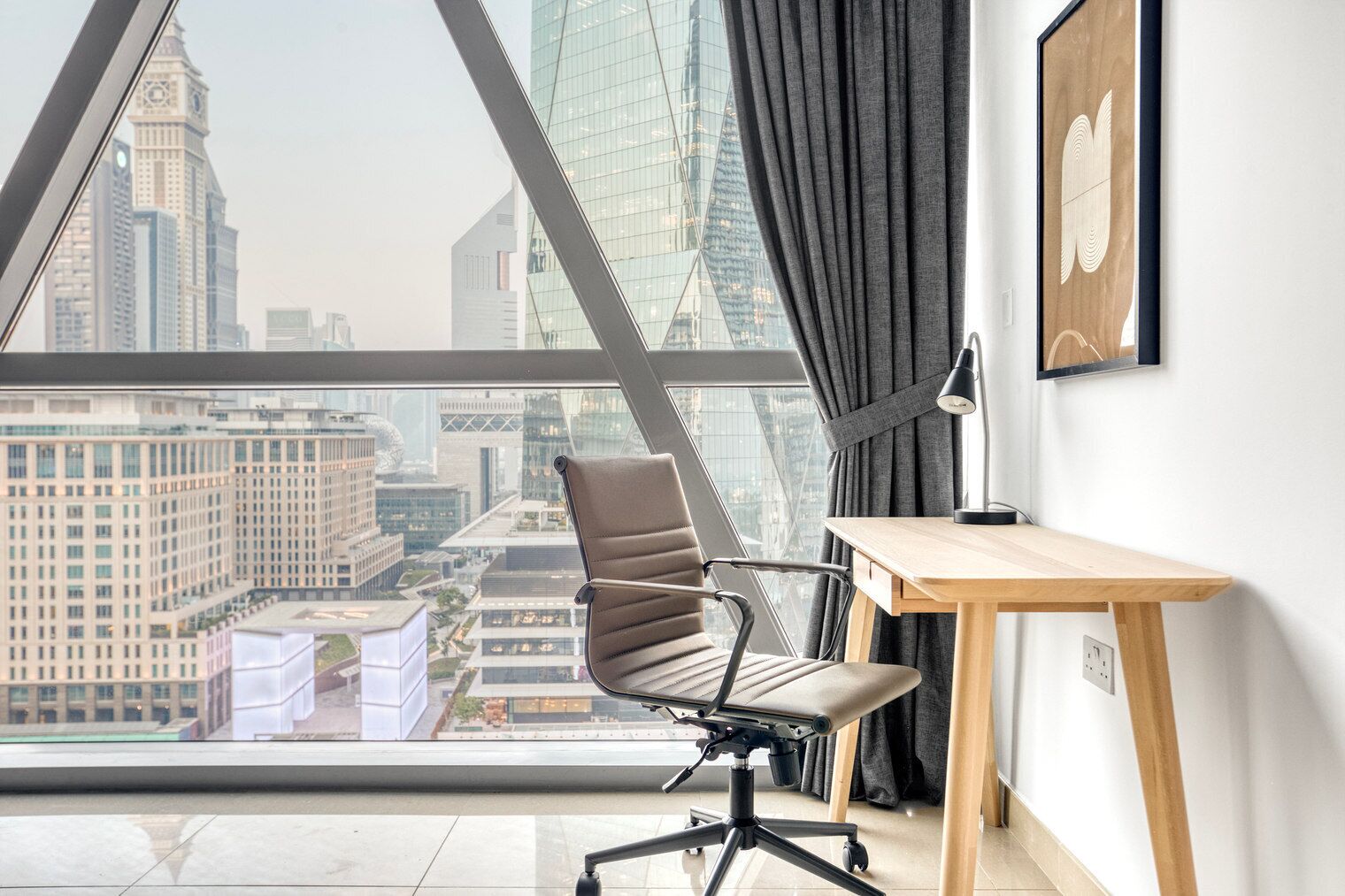 Un espace de bureau moderne avec vue sur le paysage urbain, grâce à de grandes fenêtres, comprenant un bureau et une chaise.