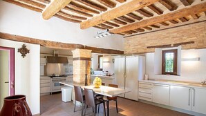A modern kitchen with exposed wooden beams, a central island, and white cabinetry. - Villa Mora: A characteristic and welcoming three-story villa surrounded by the greenery, with Free WI-FI. (Belvedere Ostrense)