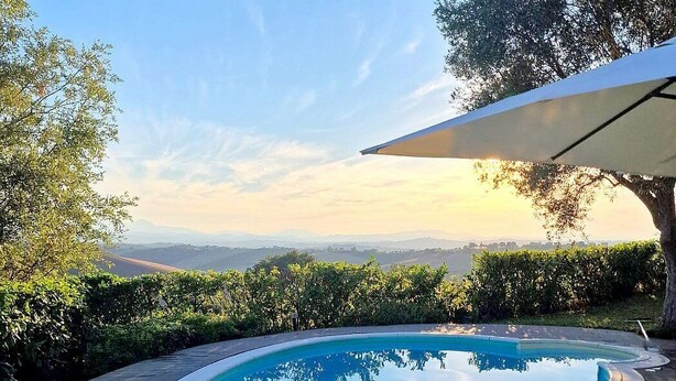 A swimming pool with a curved edge, surrounded by a paved deck and lush greenery. - Villa Mora: A characteristic and welcoming three-story villa surrounded by the greenery, with Free WI-FI. (Belvedere Ostrense)