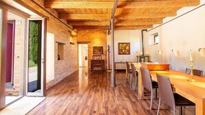 A spacious room with wooden flooring, a long table, and chairs. There is a door leading to an outdoor area. - Villa Mora: A characteristic and welcoming three-story villa surrounded by the greenery, with Free WI-FI. (Belvedere Ostrense)