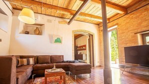 A modern living room with a sectional sofa, a coffee table, and a TV. - Villa Mora: A characteristic and welcoming three-story villa surrounded by the greenery, with Free WI-FI. (Belvedere Ostrense)