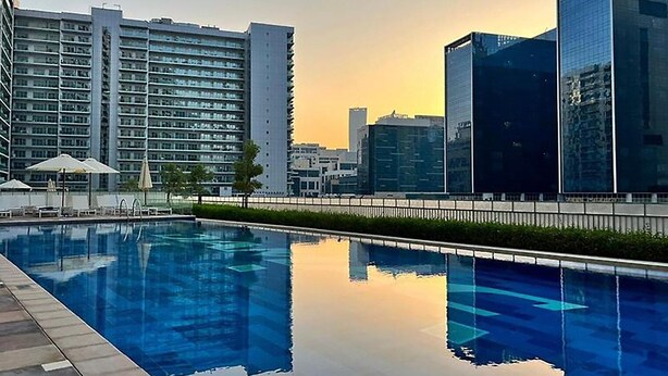 A swimming pool with a cityscape in the background.