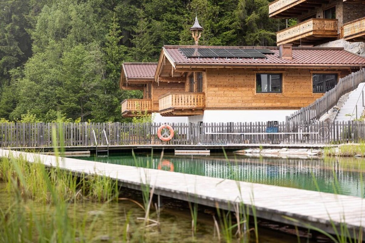 A wooden cabin with a balcony, a wooden deck, and a lifebuoy.