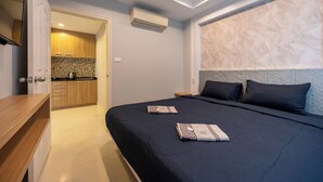 Quarto moderno com uma cama grande, mesa de cabeceira e painel de cabeceira embutido.