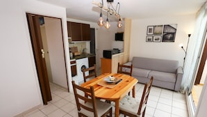 A compact living space with a dining area, kitchenette, and a sofa. - St Cyprien beautiful cozy apartment sea view (Saint-Cyprien)