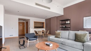 Una sala de estar moderna con un sofá gris, un sillón azul y una mesa de centro de madera.