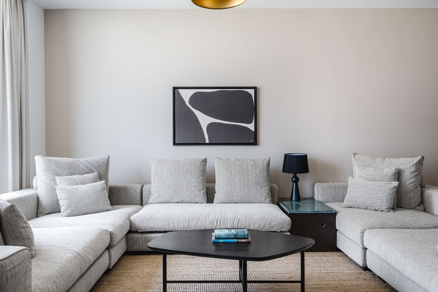 A modern living room with a sectional sofa, a coffee table, and a floor lamp.