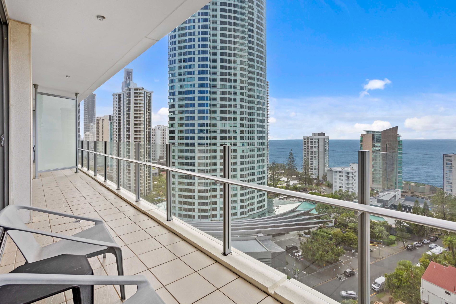 A balcony with a view of a tall building and the ocean.