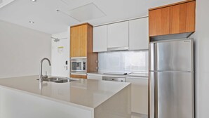 Una cocina moderna con una isla central, electrodomésticos de acero inoxidable y armarios de madera.