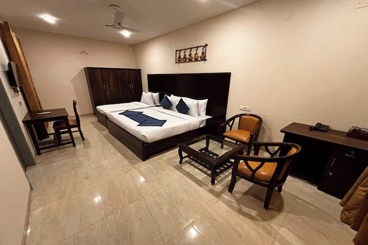 Une chambre d’hôtel avec un grand lit, un bureau, une chaise et une petite table.