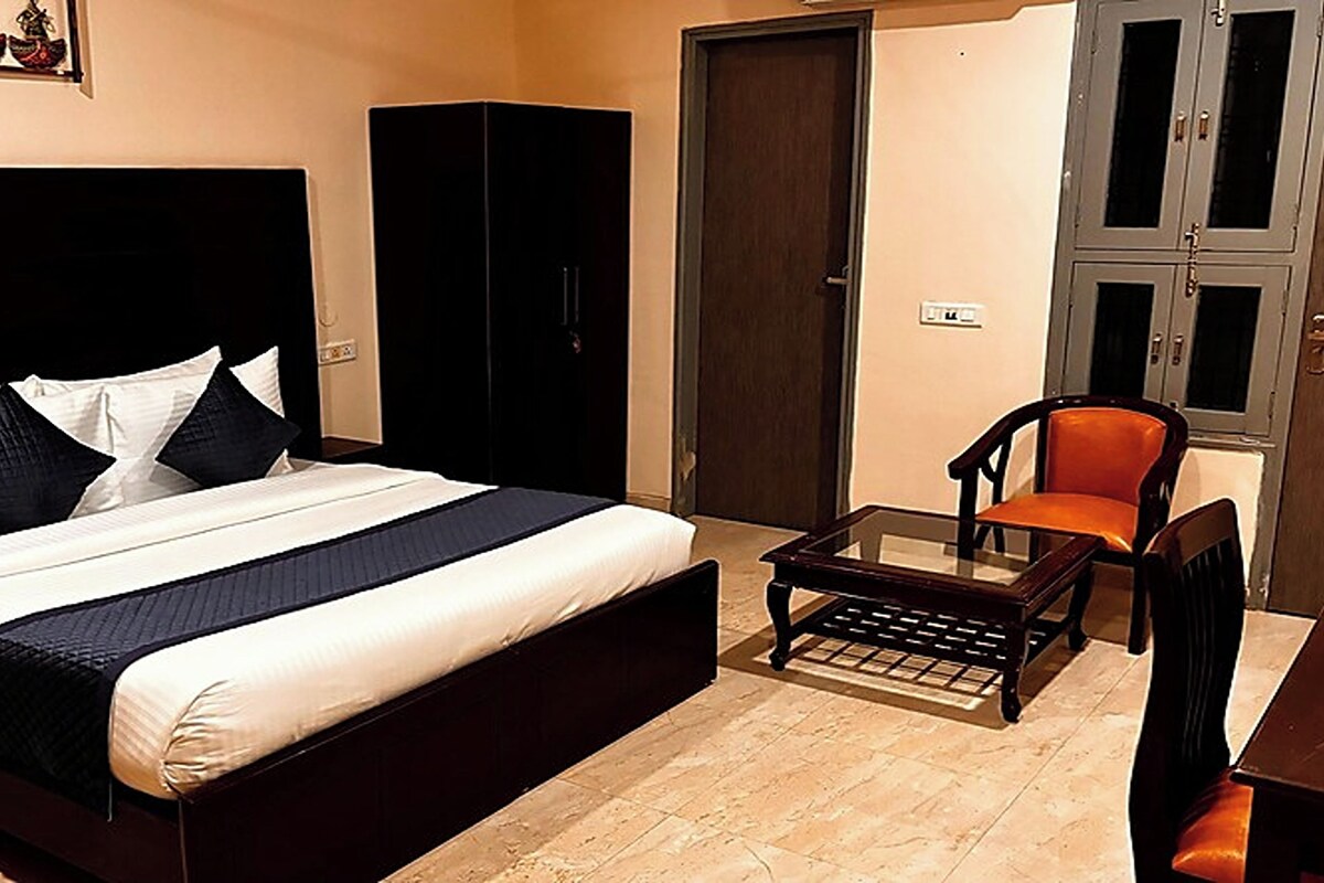 Een hotelkamer met een groot bed, een kleine tafel, een stoel en een kledingkast.