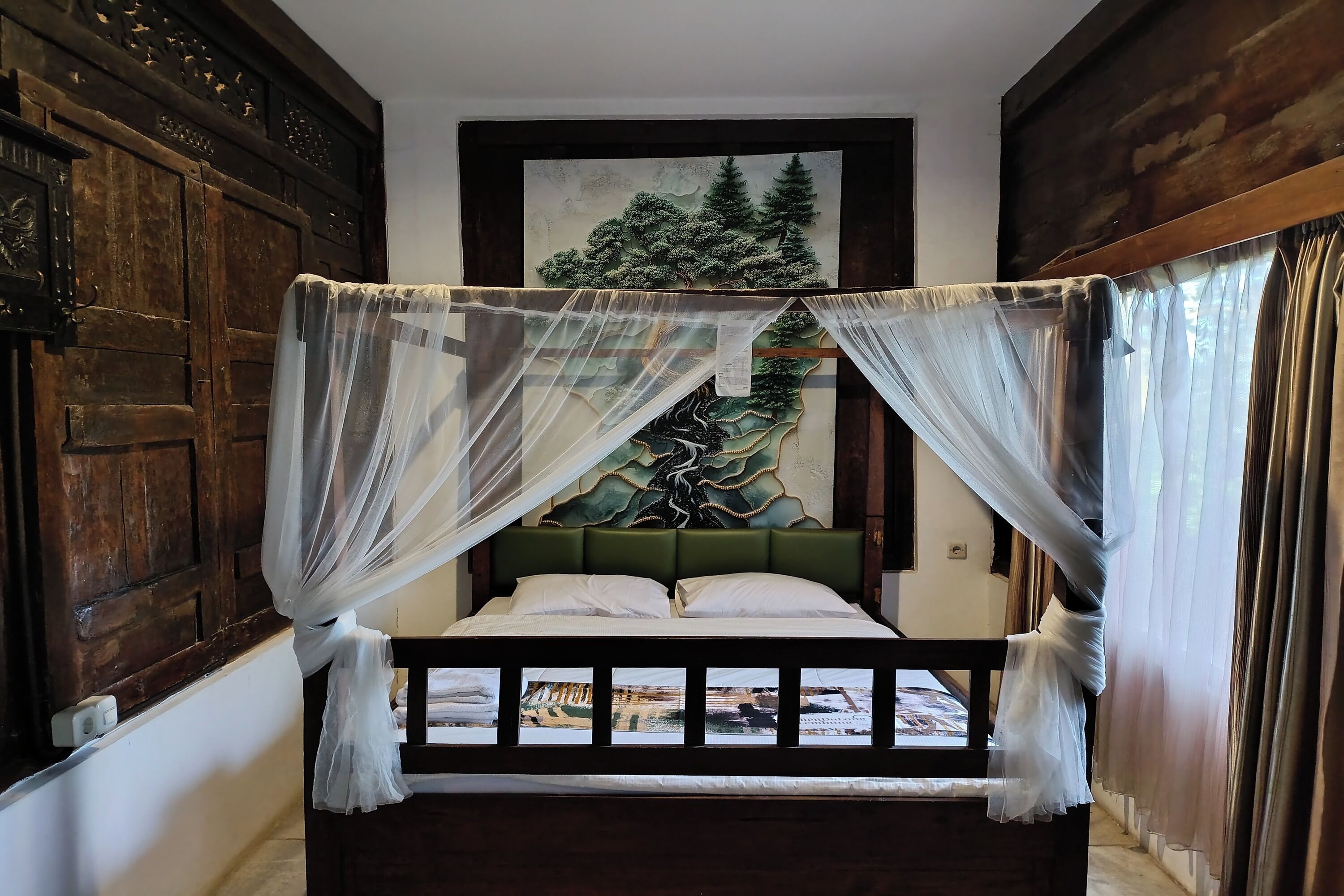 A bed with a green headboard, white bedding, and a canopy.