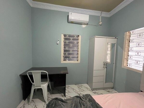 A room with a desk, a wardrobe, a bed, and a window with decorative bars. - Al-Barokah Embun Syariah (Palembang)