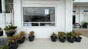 Un bâtiment portant une enseigne indiquant qu’il s’agit d’un hôtel, d’une salle de réception et qu’il dispose d’une piscine.