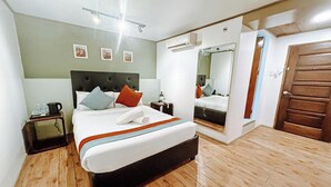 Een slaapkamer met een bed, nachtkastje en een spiegel.