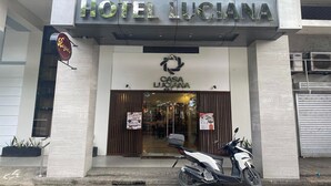 De ingang van Hotel Luciana, met een modern design, een zichtbare motor en een bord met Casa Luciana.