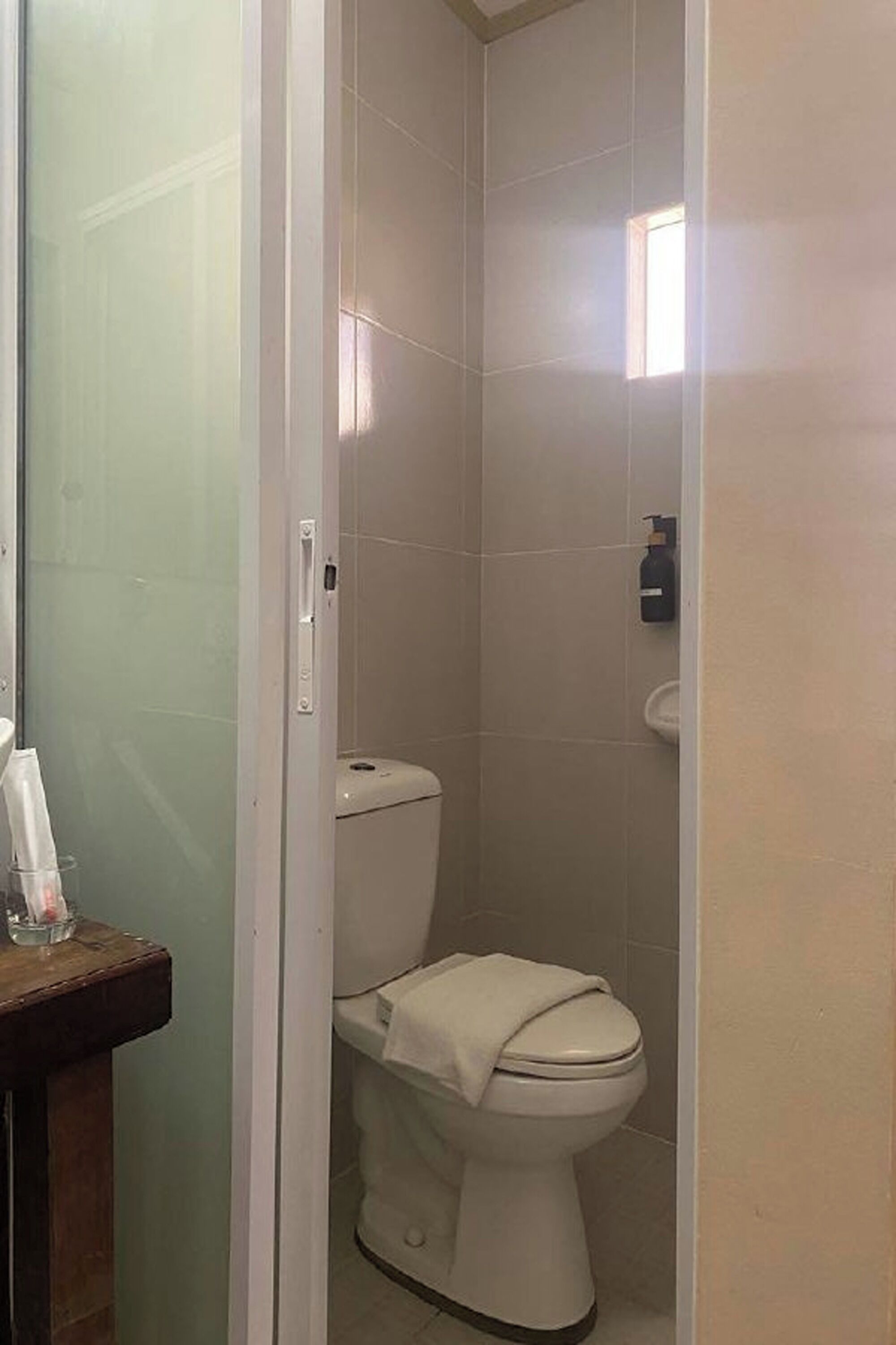 Un baño con inodoro, lavamanos y cabina de ducha de vidrio.