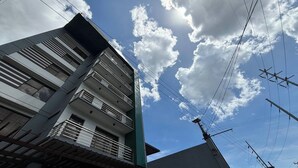 A multi-story building with balconies and a clear sky with clouds. - Yellowbell Hotel (Batangas City)