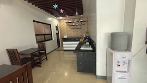 A modern kitchen with a granite countertop, a built-in refrigerator, and a coffee machine. - Yellowbell Hotel (Batangas City)