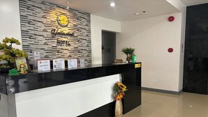 A hotel reception desk with a modern design, featuring a black and white color scheme, a welcome sign, and informational cards. - Yellowbell Hotel (Batangas City)