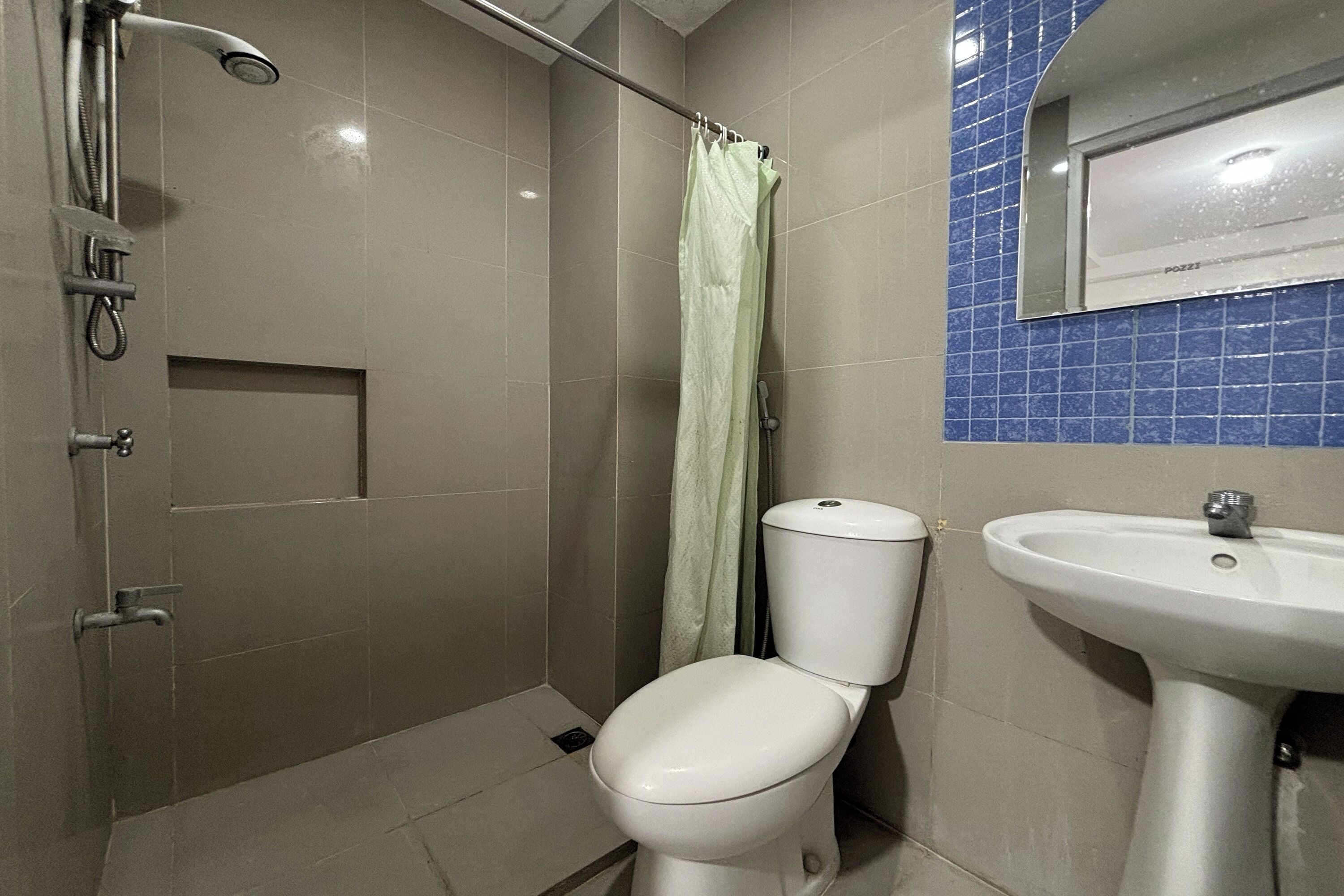 Un baño con ducha, inodoro y lavabo.