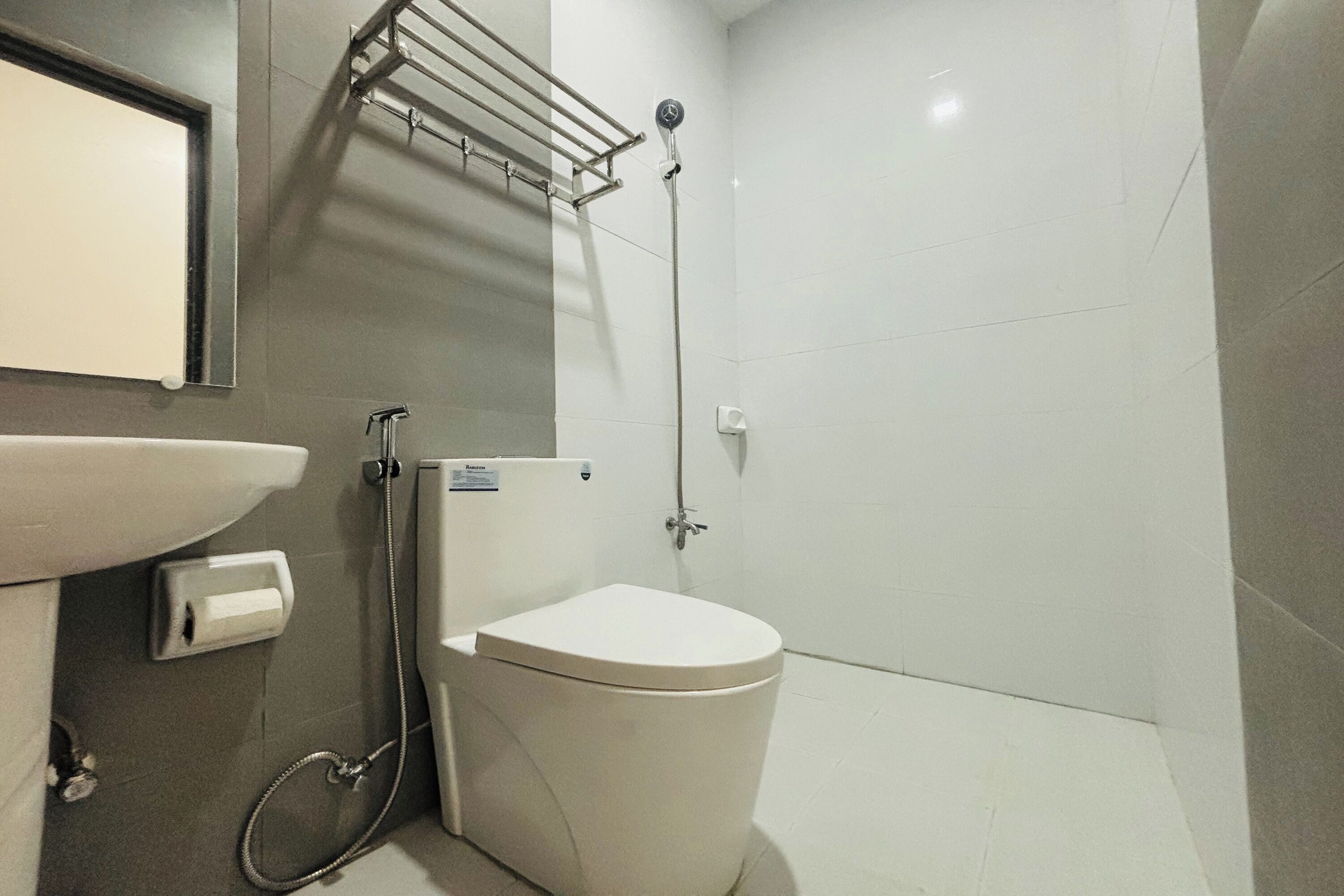 A modern bathroom with a toilet, sink, and shower.