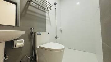 A modern bathroom with a toilet, sink, and shower.