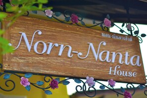 A wooden sign with the text "Norn-Nanta House" and decorative floral elements. - Norn-Nanta House (Chiang Mai)